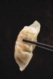 Chopsticks holding Asian dumpling