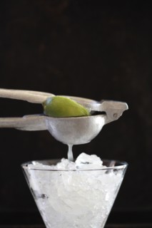 Lime being squeezed over ice