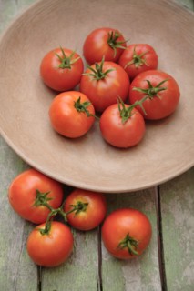 Tomatoes in bowl on wooden table
