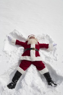 Santa Claus making snow angel outdoors