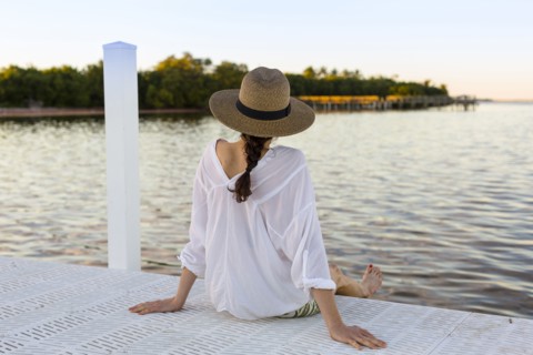 Caucasian woman sitting at edge of pier