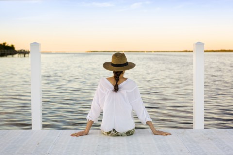 Caucasian woman sitting at edge of pier