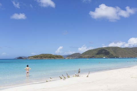 Caucasian woman standing in ocean on tropical beach