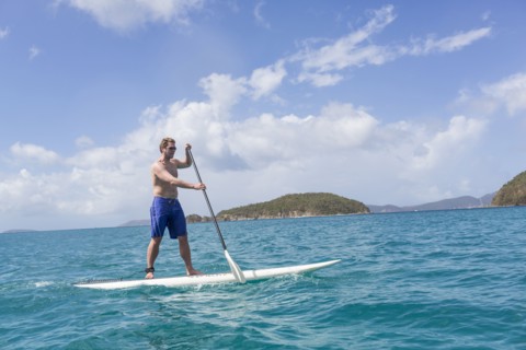 Caucasian man standing on paddle board on ocean