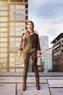 Mixed race woman with bow and arrow on urban rooftop