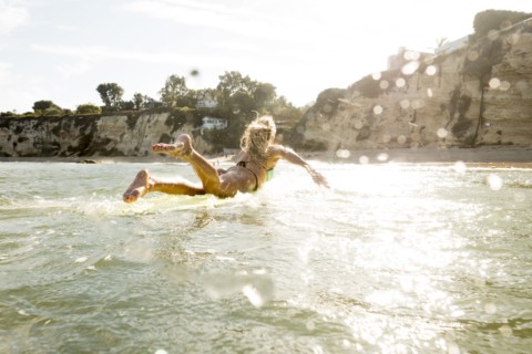 Caucasian woman paddling on surfboard in ocean