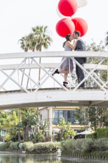 Kissing couple celebrating on bridge with balloons