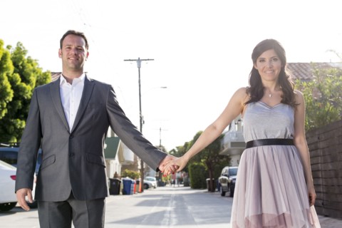 Smiling couple holding hands in alley