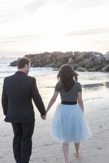 Couple holding hands and walking on beach