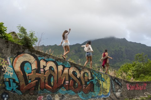 Friends walking on graffiti wall near mountain