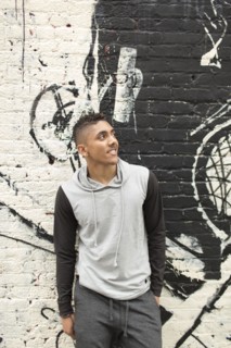 Smiling Mixed Race man standing near mural on wall