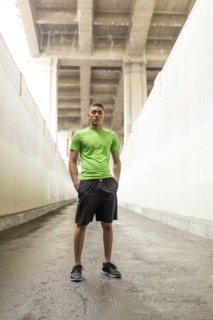 Serious Mixed Race man standing under bridge