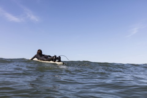 Caucasian man paddling on surfboard
