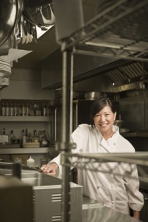 Smiling Chinese chef standing in commercial kitchen