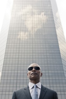 Black businessman standing near highrise