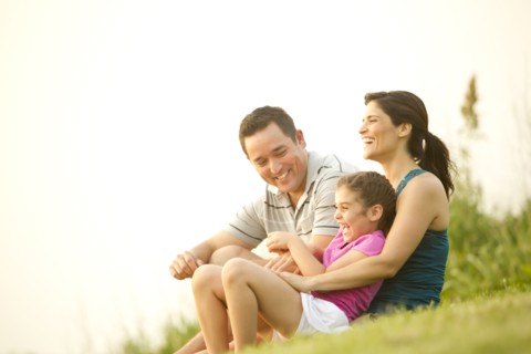 Family sitting in grass together