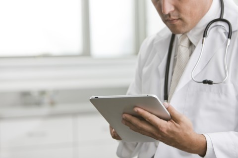 Mixed race doctor using digital tablet