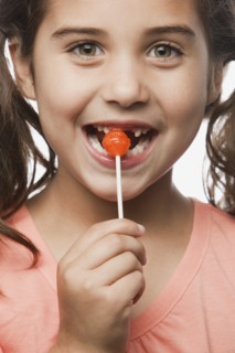 Mixed race girl eating lollipop