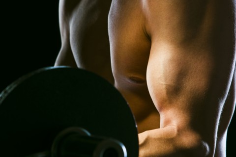 Caucasian man exercising with barbells