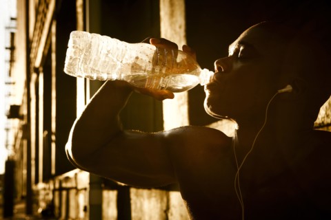 African American man drinking water after exercise
