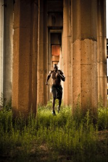 African American man jogging between pillars