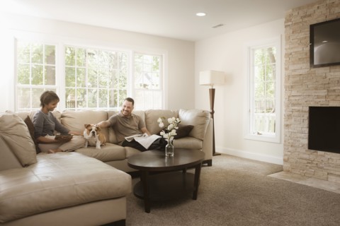Couple sitting on sofa with English bulldog