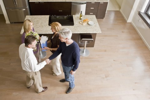 Caucasian friends talking together in modern kitchen