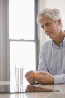 Caucasian man taking medicine