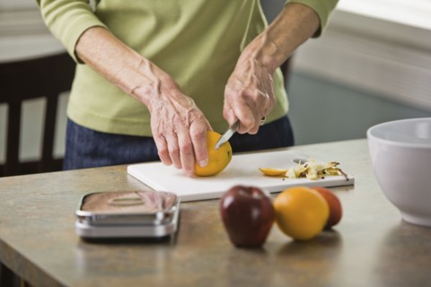 Senior woman cutting fruit