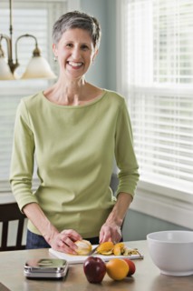 Senior woman cutting fruit