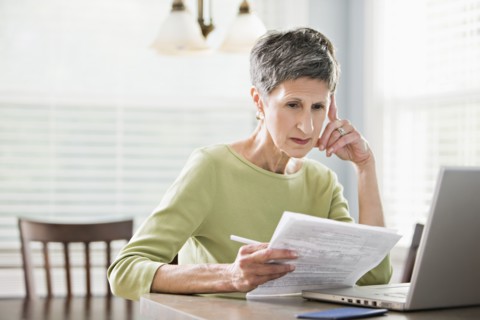 Senior woman paying bills on laptop