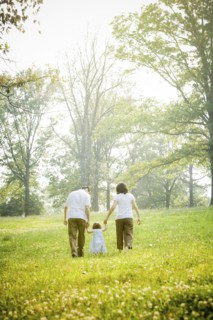 Parents walking with daughter in field