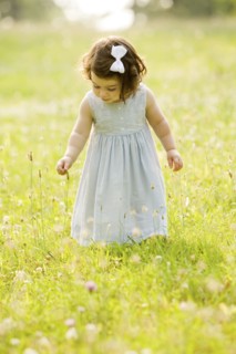 Caucasian girl picking flowers in field