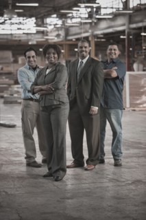 Business people and workers standing in warehouse