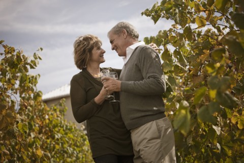 Caucasian couple drinking wine in vineyard