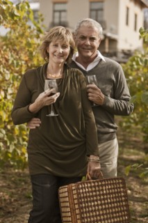 Caucasian couple drinking wine in vineyard