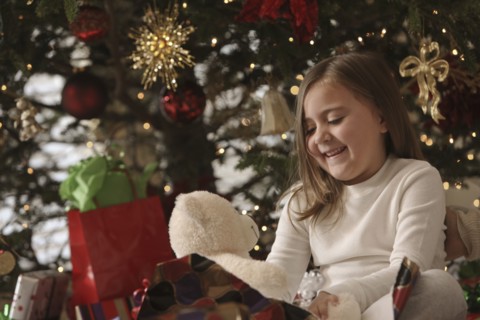 Mixed race girl opening gifts Christmas morning