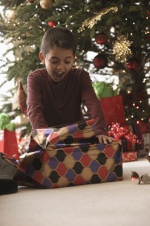 Hispanic boy opening gifts Christmas morning