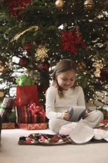 Mixed race girl opening gifts Christmas morning