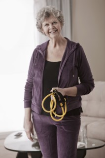 Caucasian woman holding exercise bands in living room