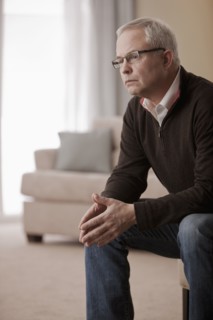 Serious Caucasian man sitting in living room