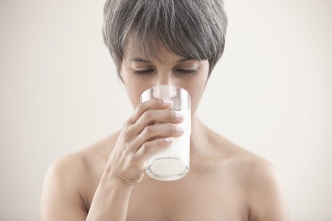 Mixed race woman drinking milk