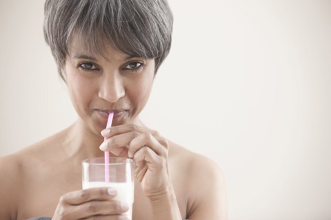 Mixed race woman drinking milk