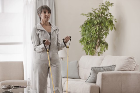 Mixed race woman exercising in living room