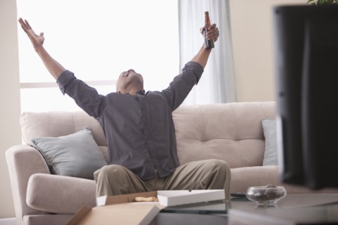 Black man cheering and watching television