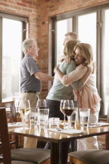 Caucasian friends hugging in restaurant