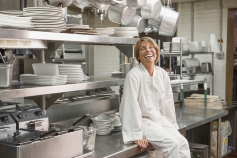 Caucasian chef sitting in commercial kitchen