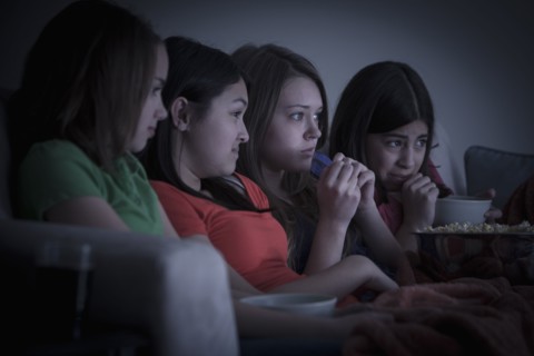 Friends eating popcorn and watching a movie