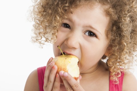 Mixed race girl eating apple