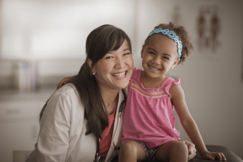 Doctor and girl smiling in doctor's office